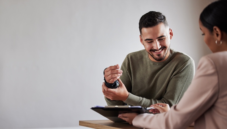 worker in a wrist brace speaks with an agent about a workers comp insurance claim