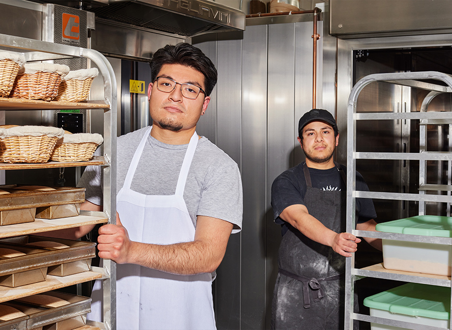 bakers pushing racks of bread