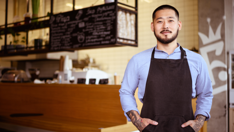 A restaurant owner stands in front of a restaurant