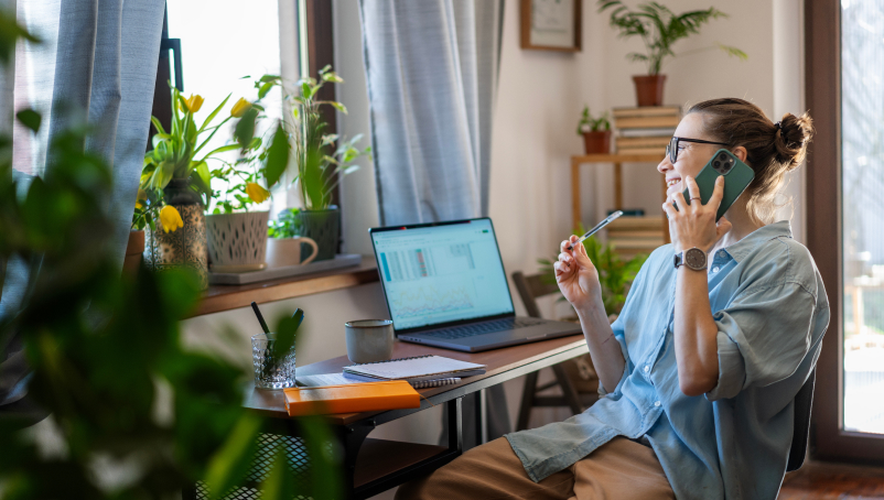 person at a desk talking on a cell phone